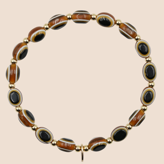 A khaki brown evil eye bracelet including a 14k gold tag and beads